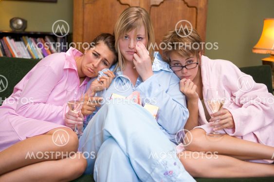 Three young women crying together in their pyjamas