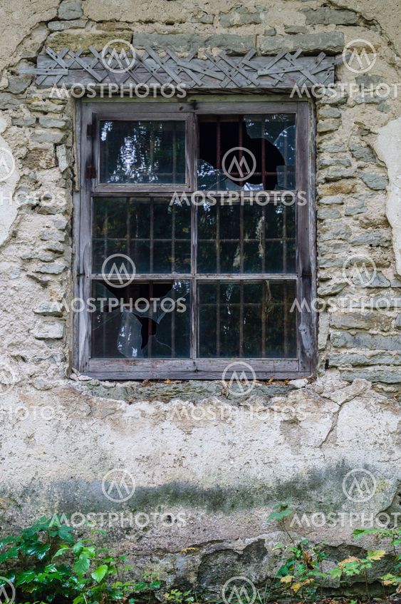 Window in old abandoned house with broken glass