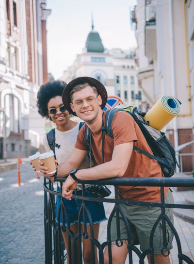 happy young interracial couple of travelers with paper...