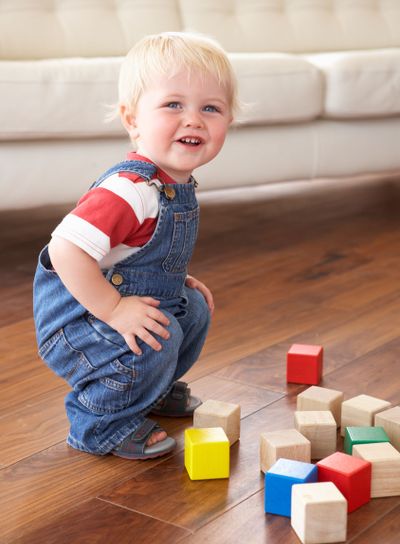 Young Boy Playing With Coloured Blocks At Home