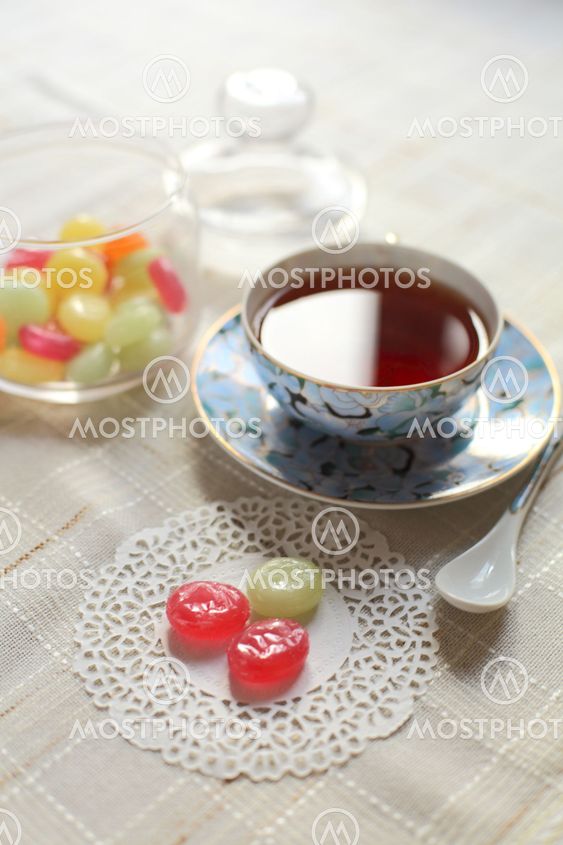 Tea with coloured sugar candies in a glass can