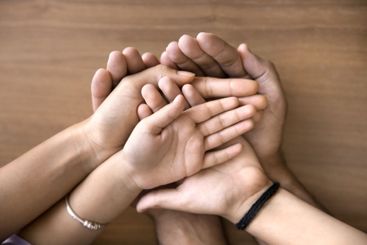 Mother, father and two kids stacked their palms...