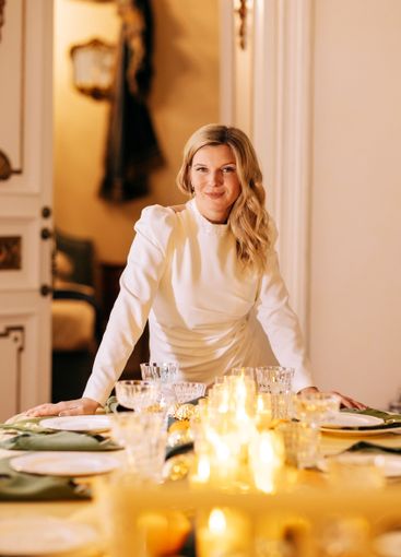Charming young woman in white evening dress stands near...