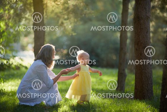 Mother and daughter walk in the Sunny summer forest