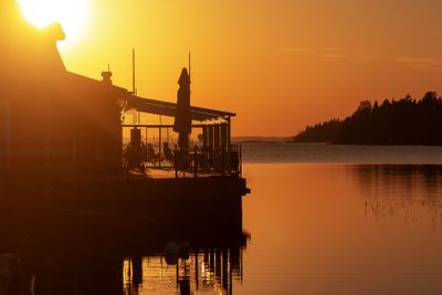 Seaside restaurant in a orange sunset and reflective water