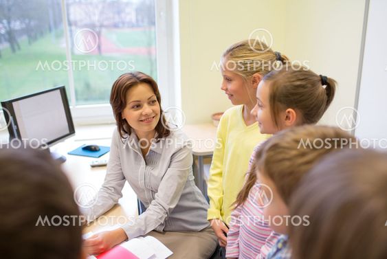 group of school kids with teacher in classroom