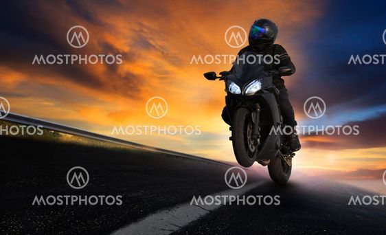 young man riding motorcycle on asphalt highways road with...