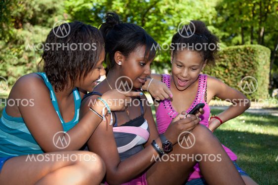 Teenage black girls using a phone,