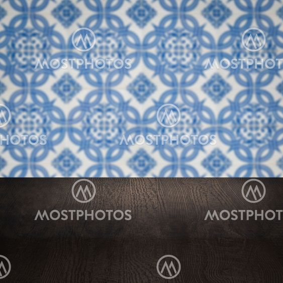 Wood table top and blur vintage ceramic tile pattern wall