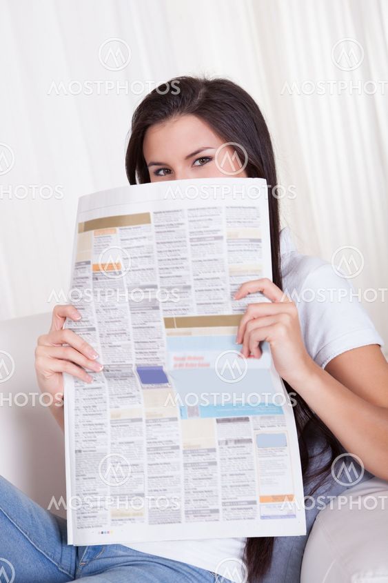 Woman sitting reading a newspaper