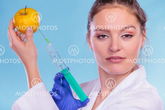 Scientist doctor injecting apple. GM Food.
