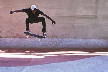 Energy, skateboard and jump with man at park for urban,...