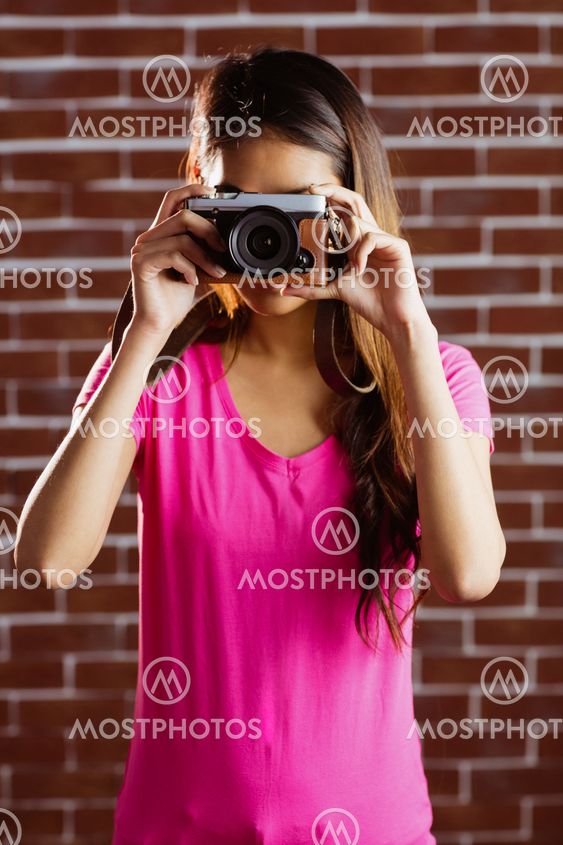 Smiling asian woman taking picture with camera