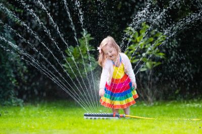 Kids playing with garden sprinkler