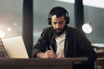 Creative, man and writing with laptop, notebook and...