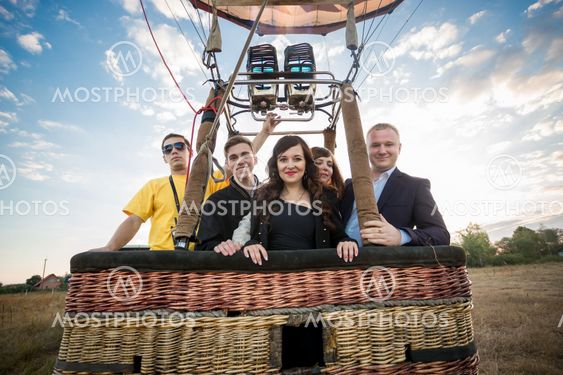 group of people posing in hot air balloon basket