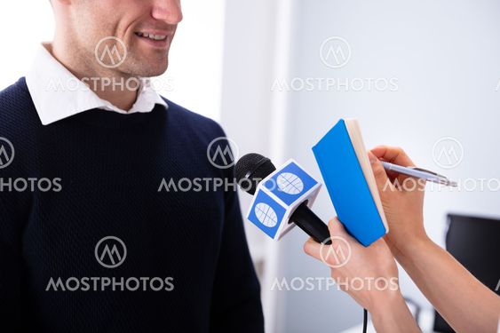 Journalist Writing On Diary While Taking An Interview