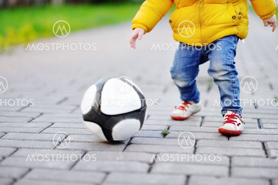 Little boy having fun playing a soccer game on sunny...