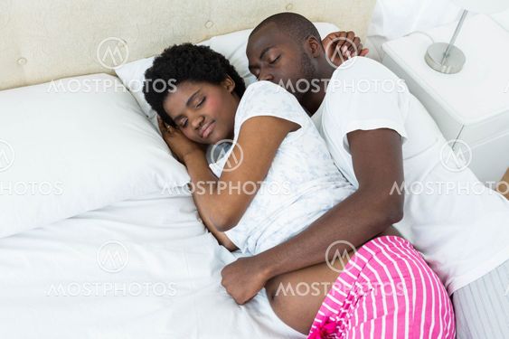 Pregnant couple relaxing on bed