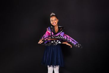 Brunette teen girl wearing butterfly wings and making...