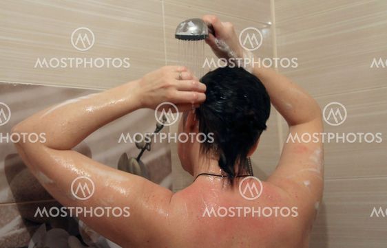 Attractive woman taking shower in bath room