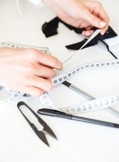 Close up of seamstress working with measuring tape