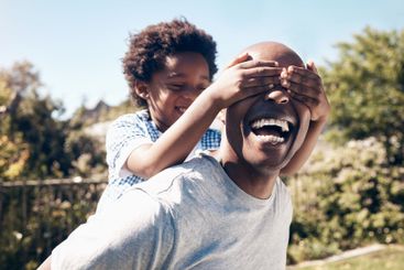 Eyes closed, backyard and dad with child for playing,...