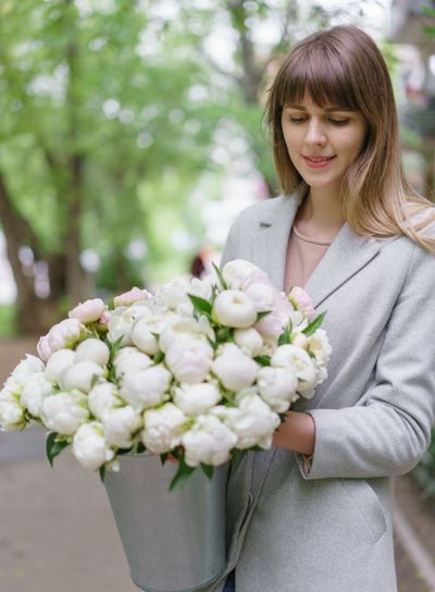Beautiful bouquet of white peonies in woomans hands ....