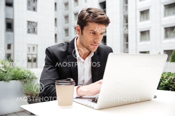 Businessman using laptop in outdoor cafe