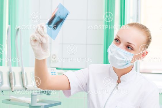 woman doctor in protective mask looking at x-ray