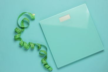 The concept of losing weight. Scales with measuring tape...