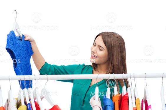 happy woman choosing clothes at home wardrobe