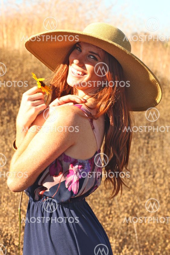 Young Beautiful Woman on a Field in Summer Time