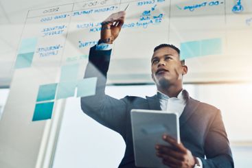 Corporate, man and writing for ideas on glass for...