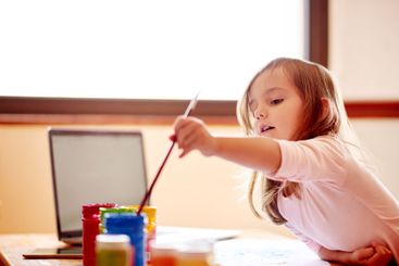 Creative, painting or child in home with laptop for...