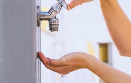 Woman drinking water from street tap
