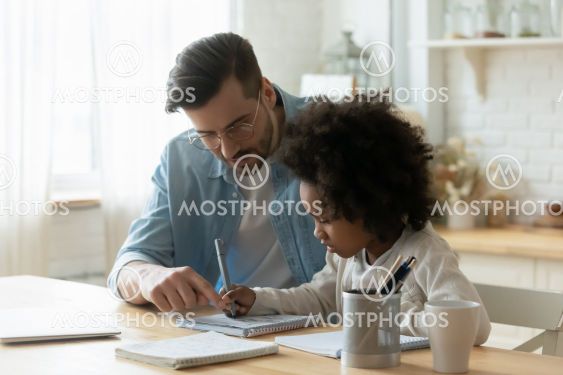Male tutor helps understand arithmetic task to little...
