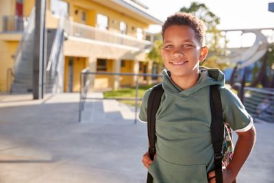 Portrait of smiling elementary school boy with his backpack