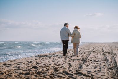 senior couple walking on seashore