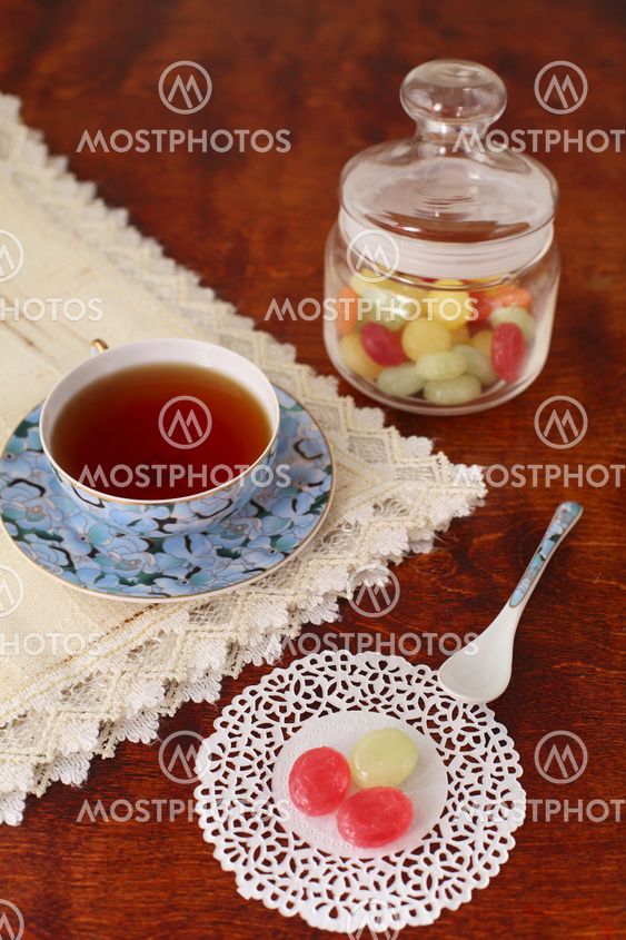 Tea with coloured sugar candies in a glass can