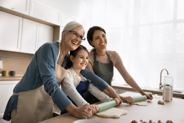 Senior grandmother young mother little daughter rolling...