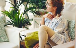 Thoughtful woman witting outdoor home in the terrace...