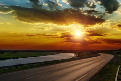 dramatic sunset over asphald road