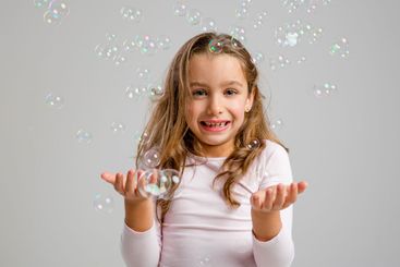 Girl playing with soap bubbles