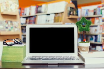 Workspace setup at a cozy bookstore with a laptop and...