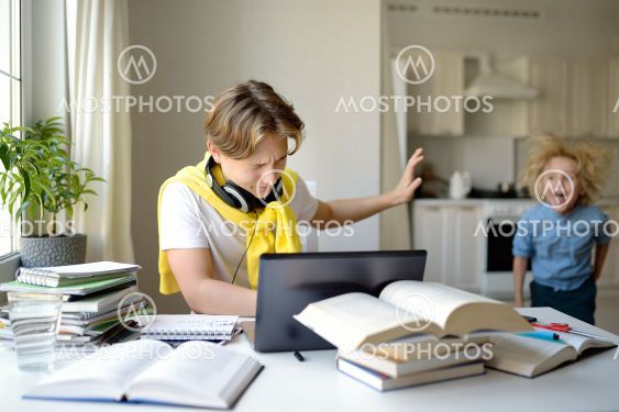 Teenager boy study at home. Online education and...