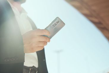 City, phone and hands of businessman typing for network,...