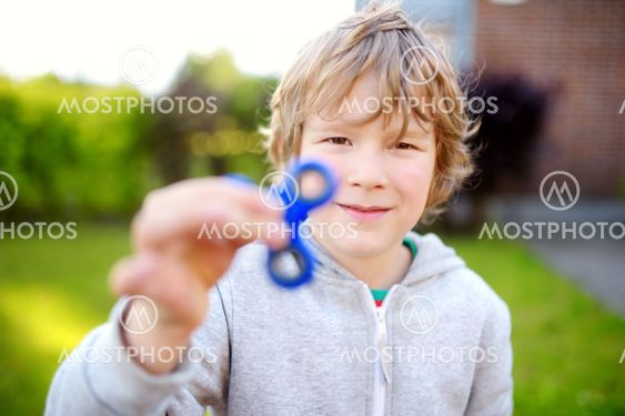 Cute school boy playing with fidget spinner on the...