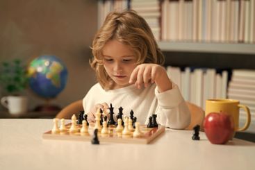 Clever concentrated and thinking child playing chess....