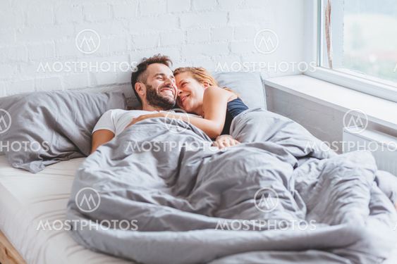 Young couple enjoying bed time in the morning